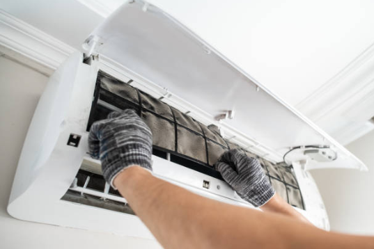Technician servicing a AC air filter during routine maintenance in a residential home.