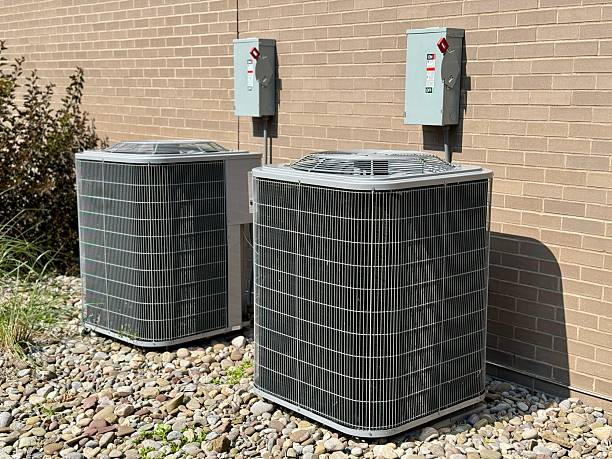 Two outdoor air conditioning condenser units installed beside a commercial building, providing cooling as part of a central HVAC system.